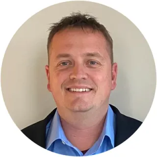 Bradley Wyatt smiling in a light blue shirt and dark blazer
